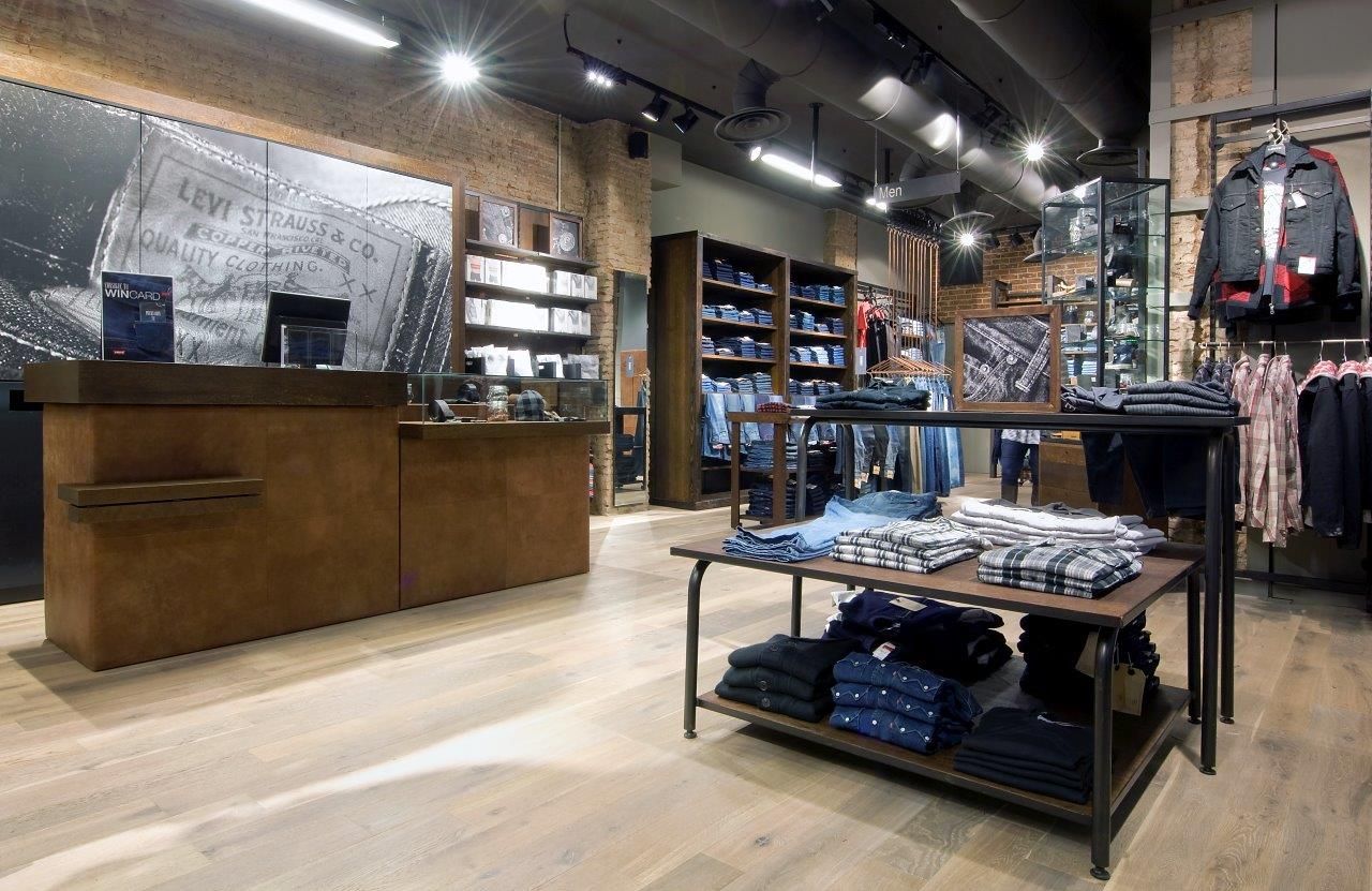 Una tienda llena de mucha ropa y un mostrador.