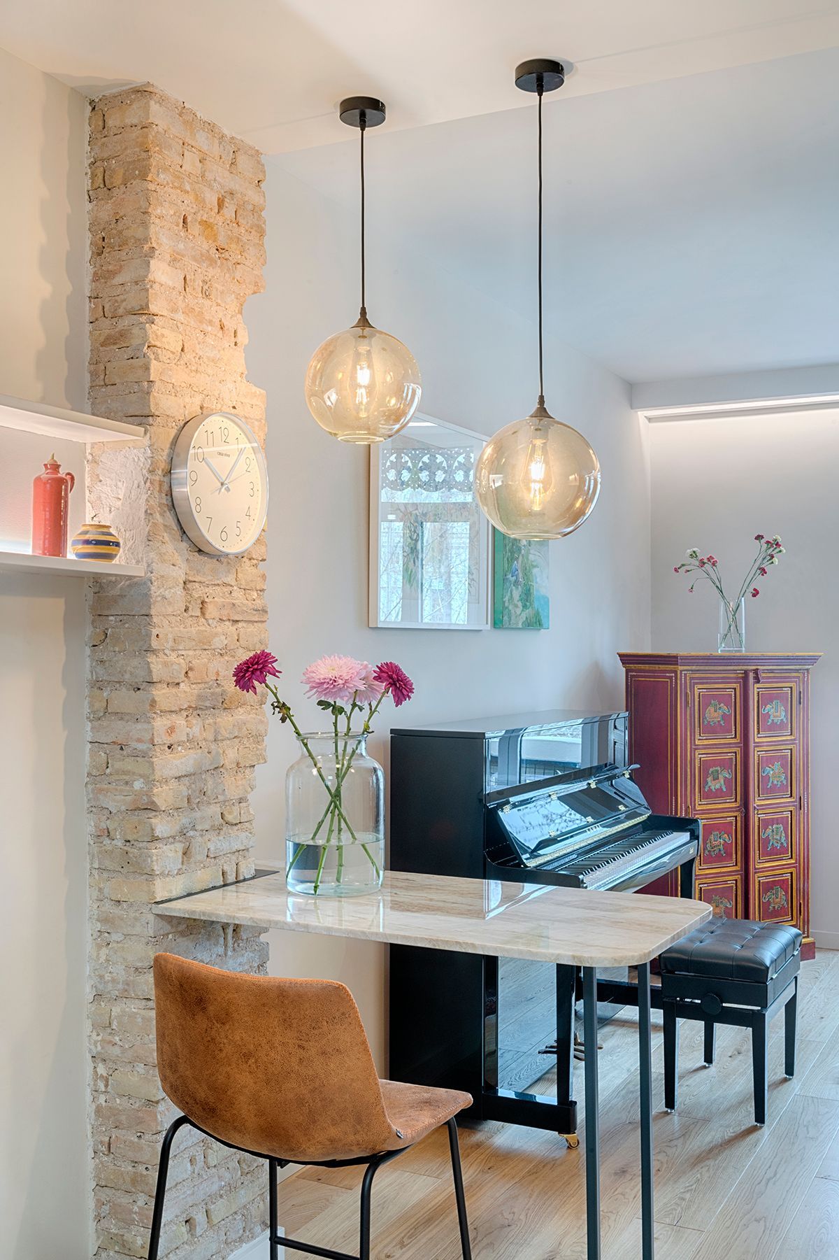 Una sala de estar con piano, mesa y sillas.