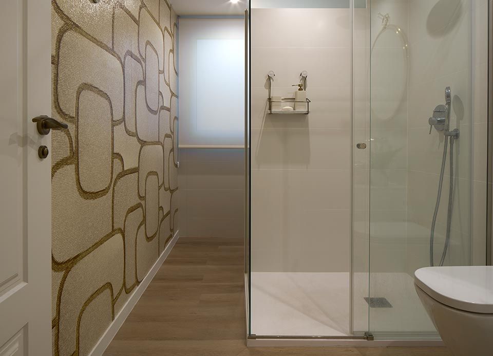 Un baño con ducha a ras de suelo y un inodoro.