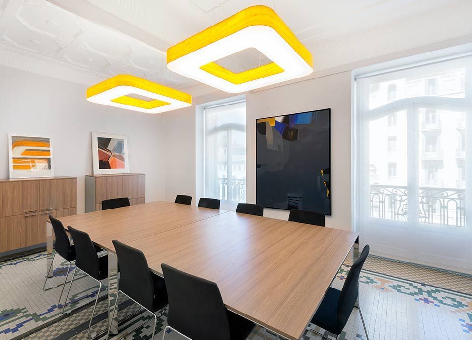 Una sala de conferencias con una larga mesa de madera y sillas.