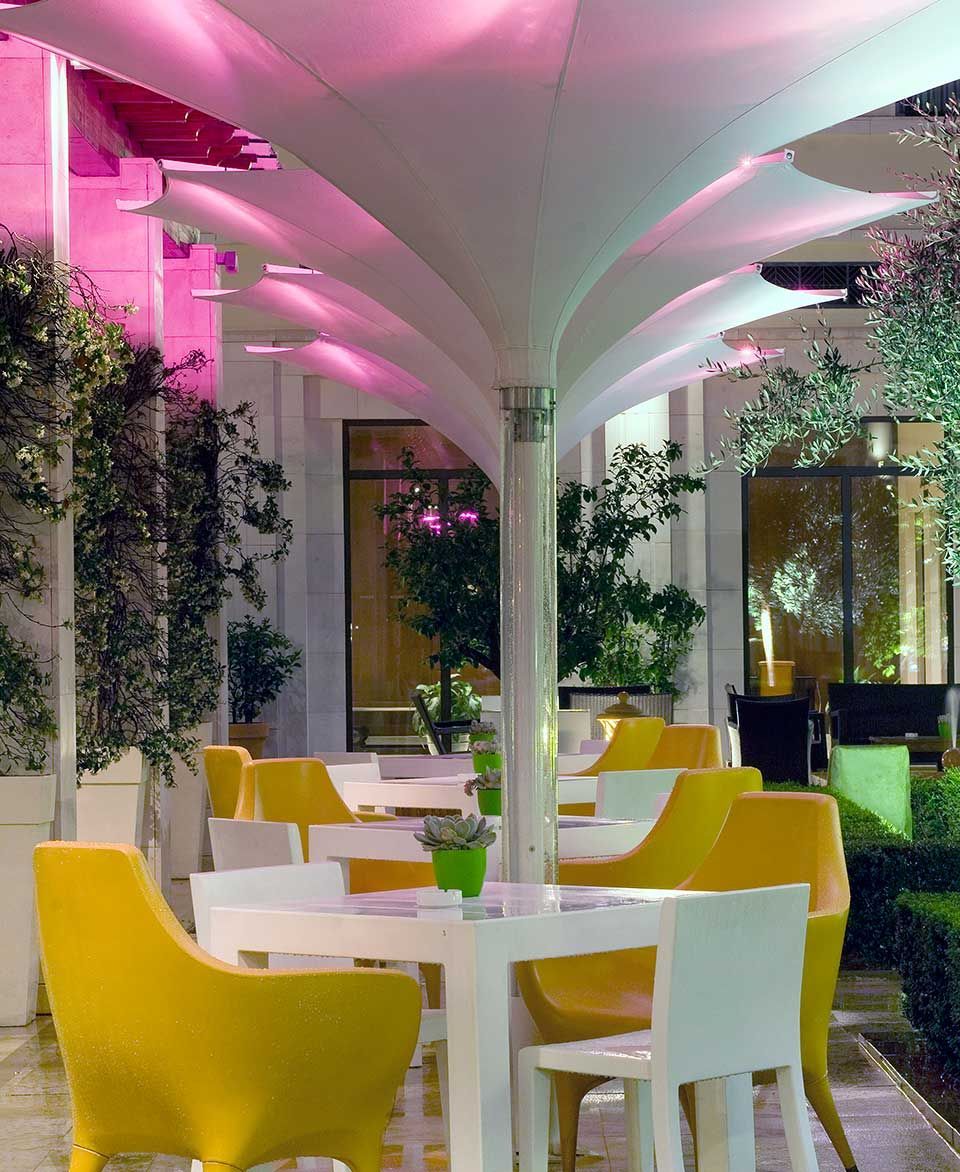 Un restaurante con sillas amarillas y mesas blancas.