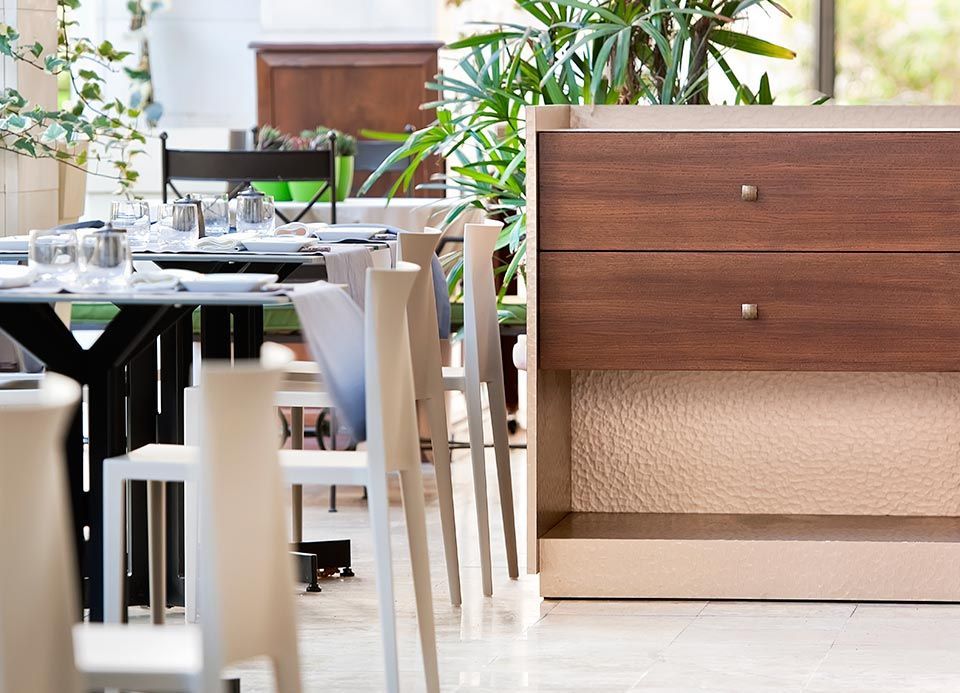 Un restaurante con mesas y sillas y un aparador de madera.