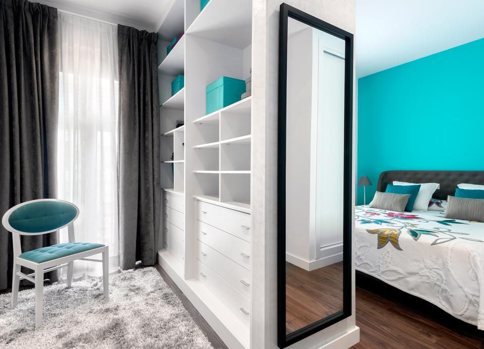 Un dormitorio con un amplio vestidor y un espejo de cuerpo entero.