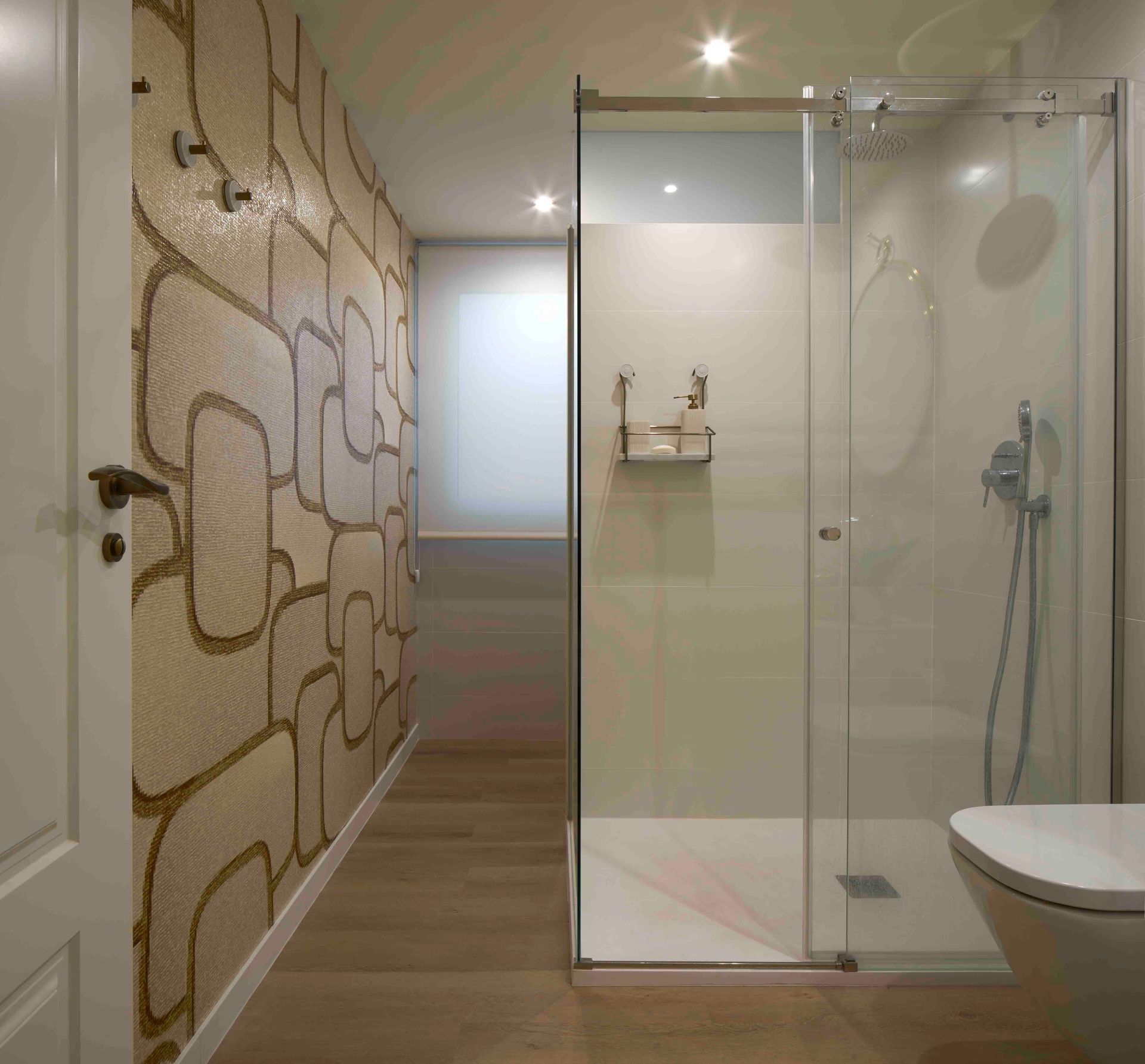 Un baño con ducha a ras de suelo y un inodoro.