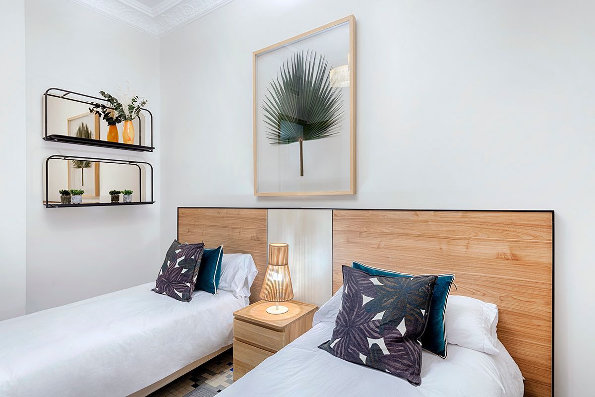 Un dormitorio con dos camas y un cuadro en la pared.