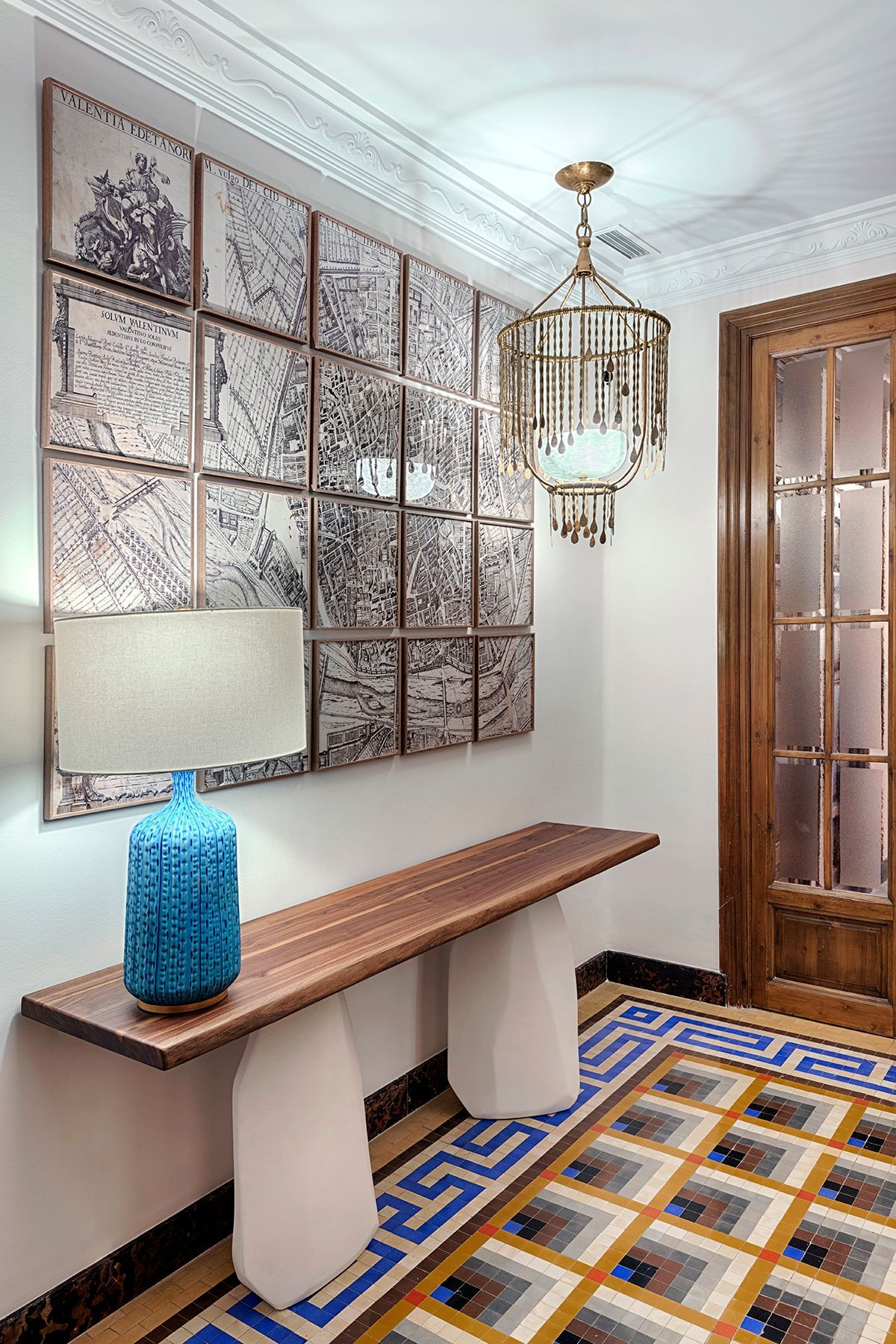 Un pasillo con una mesa de madera y un jarrón azul encima.