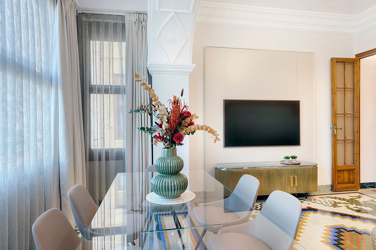 Hay un jarrón con flores en la mesa de la sala de estar.