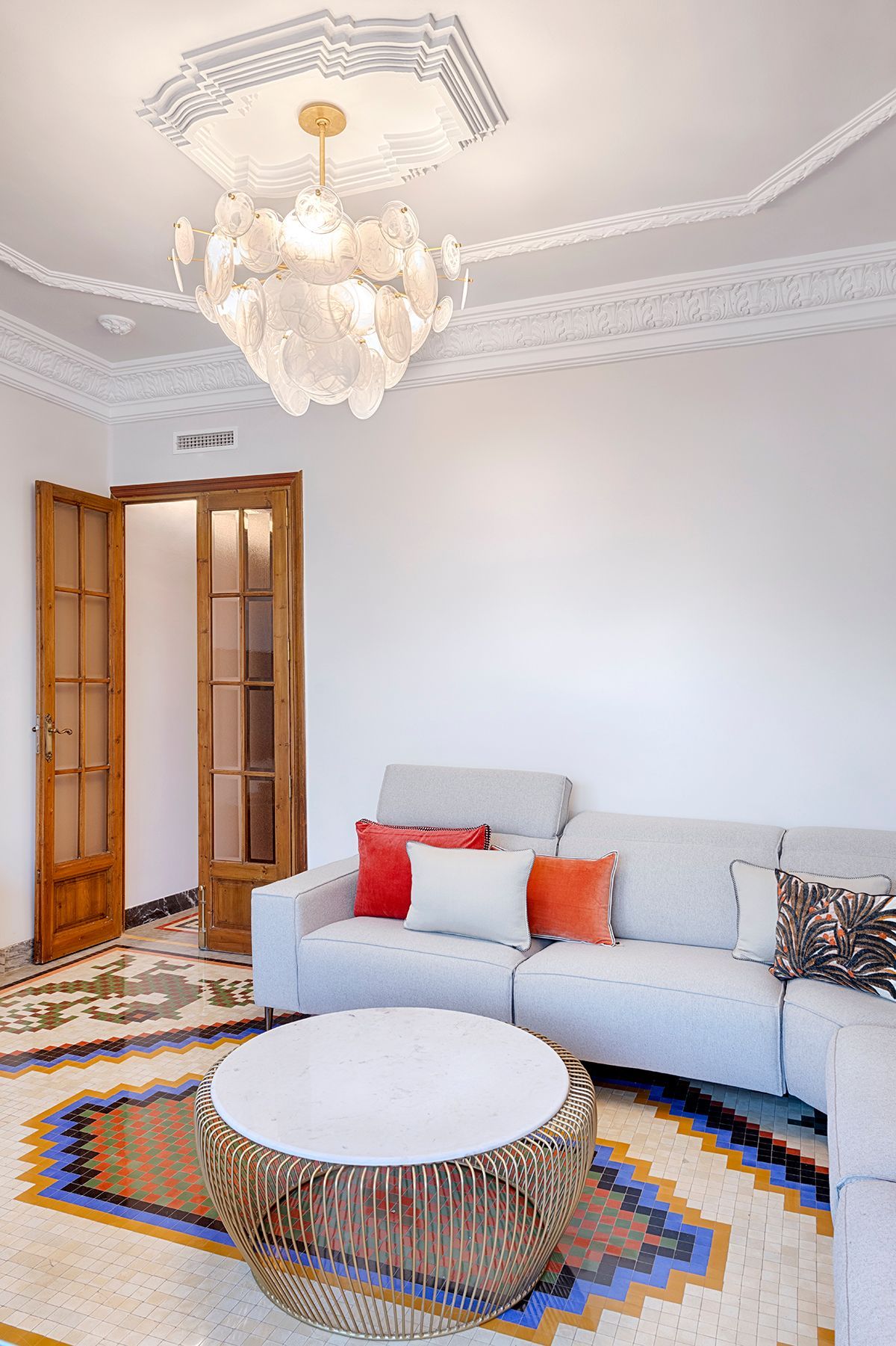 Una sala de estar con un sofá, una mesa de café y una lámpara de araña.