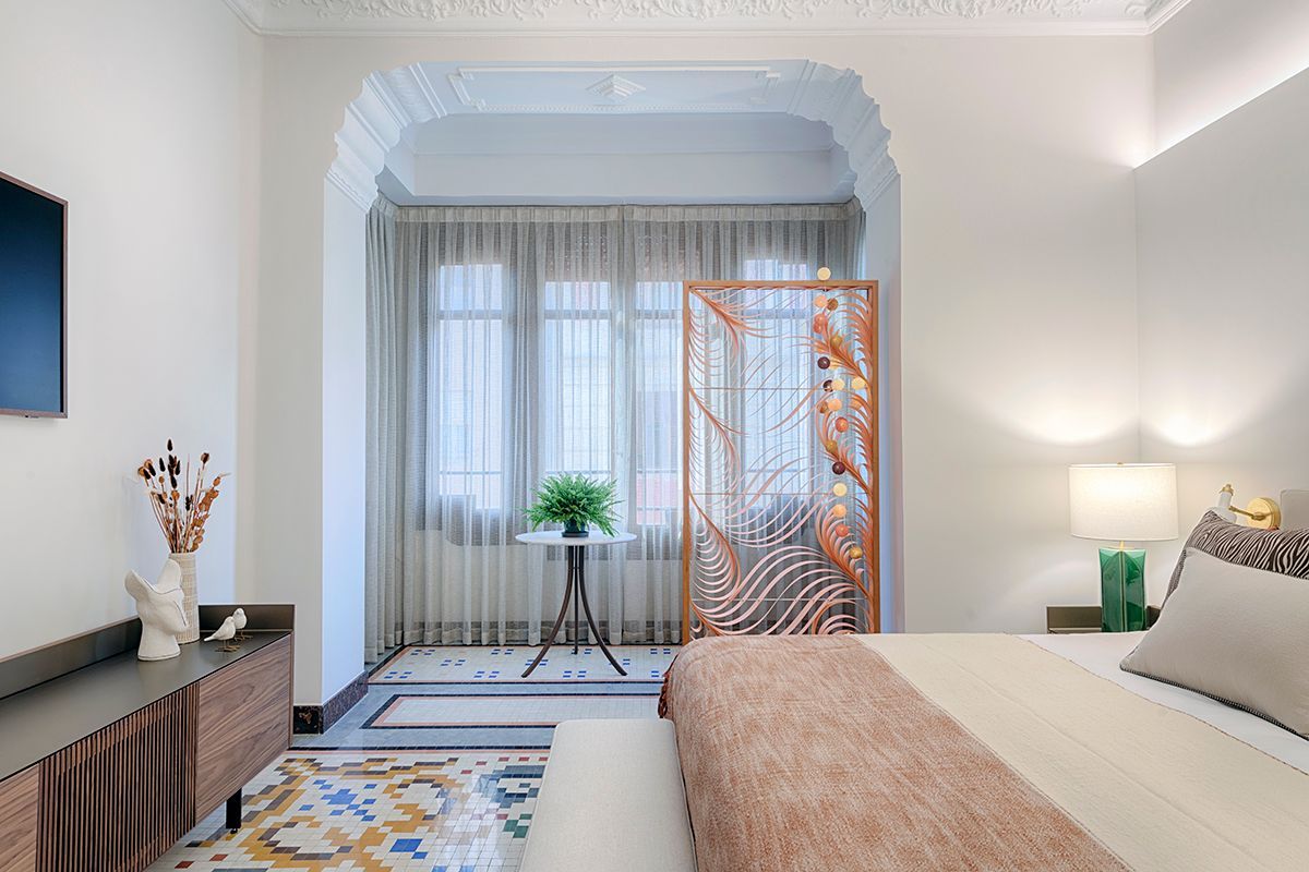 Un dormitorio con cama, televisión, mesa y ventana.