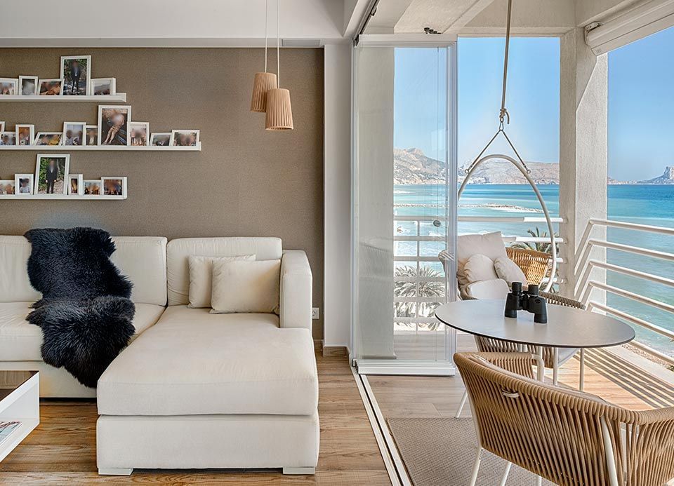 Una sala de estar con un sofá y una mesa con vista al mar.