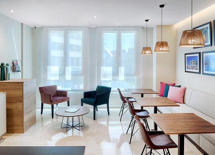 Una sala de estar con mesas y sillas y un sofá.