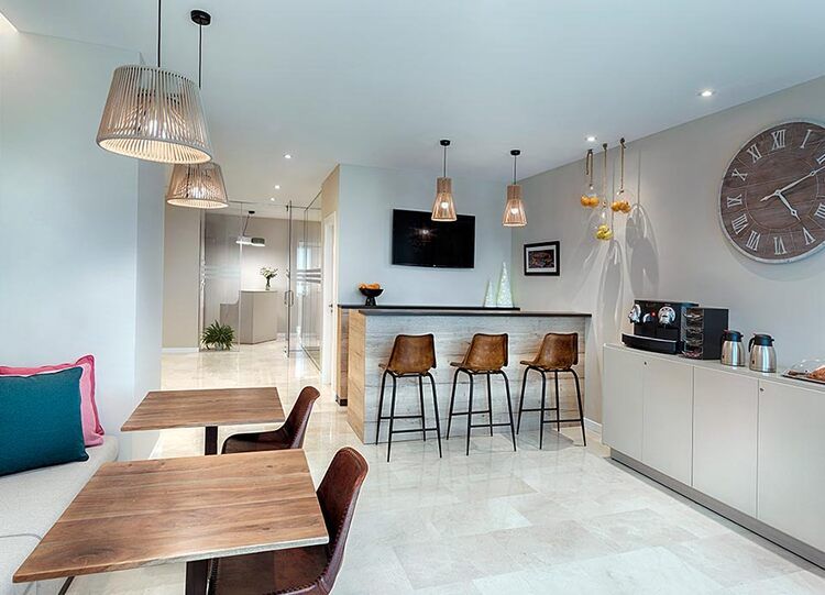 Una habitación con mesas y sillas y un reloj en la pared.