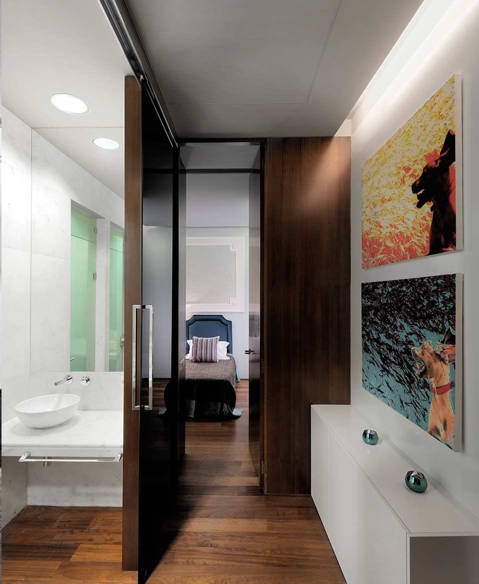 Un baño con una puerta corrediza de vidrio que conduce a un dormitorio.