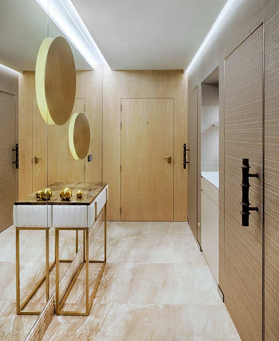 Un pasillo con una mesa y espejos en la pared.