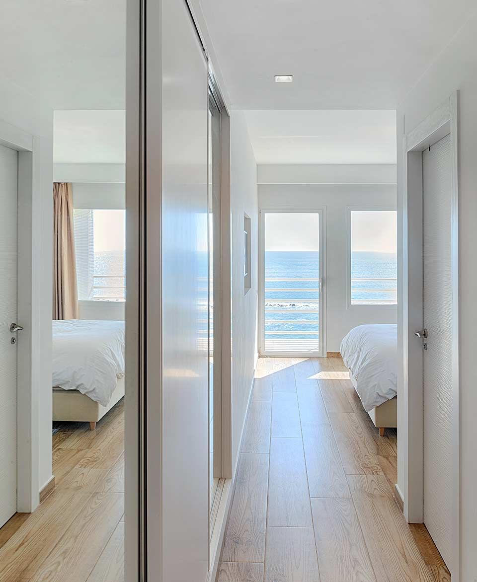 Un largo pasillo que conduce a un dormitorio con vista al océano.