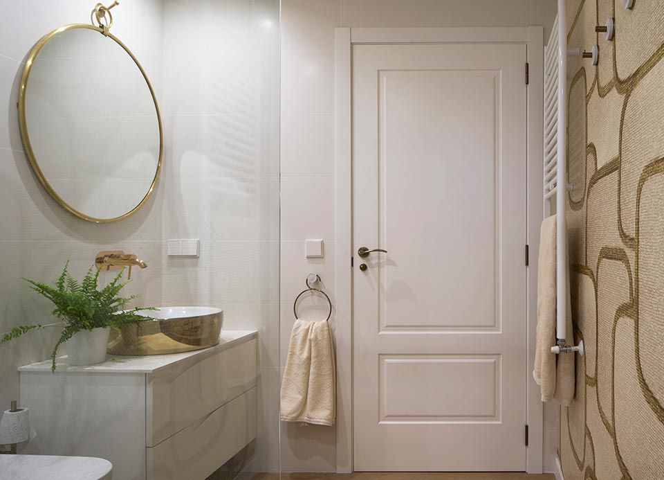 Un baño con lavabo, espejo y toallero.