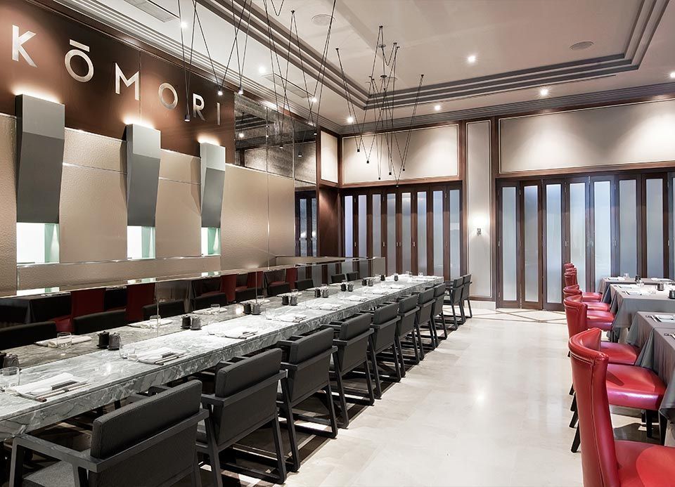 Una gran sala con mesas y sillas y la palabra komori en la pared.