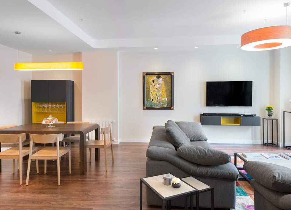 Una sala de estar con sofá, mesa, sillas y televisión.