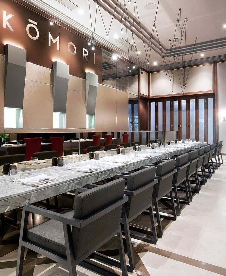 Una mesa larga en un restaurante con la palabra komori en la pared.