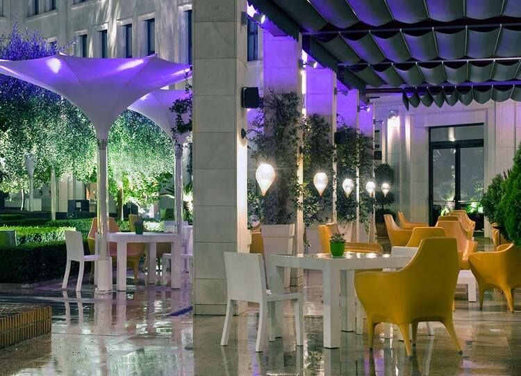 Un restaurante con mesas y sillas y un toldo morado.