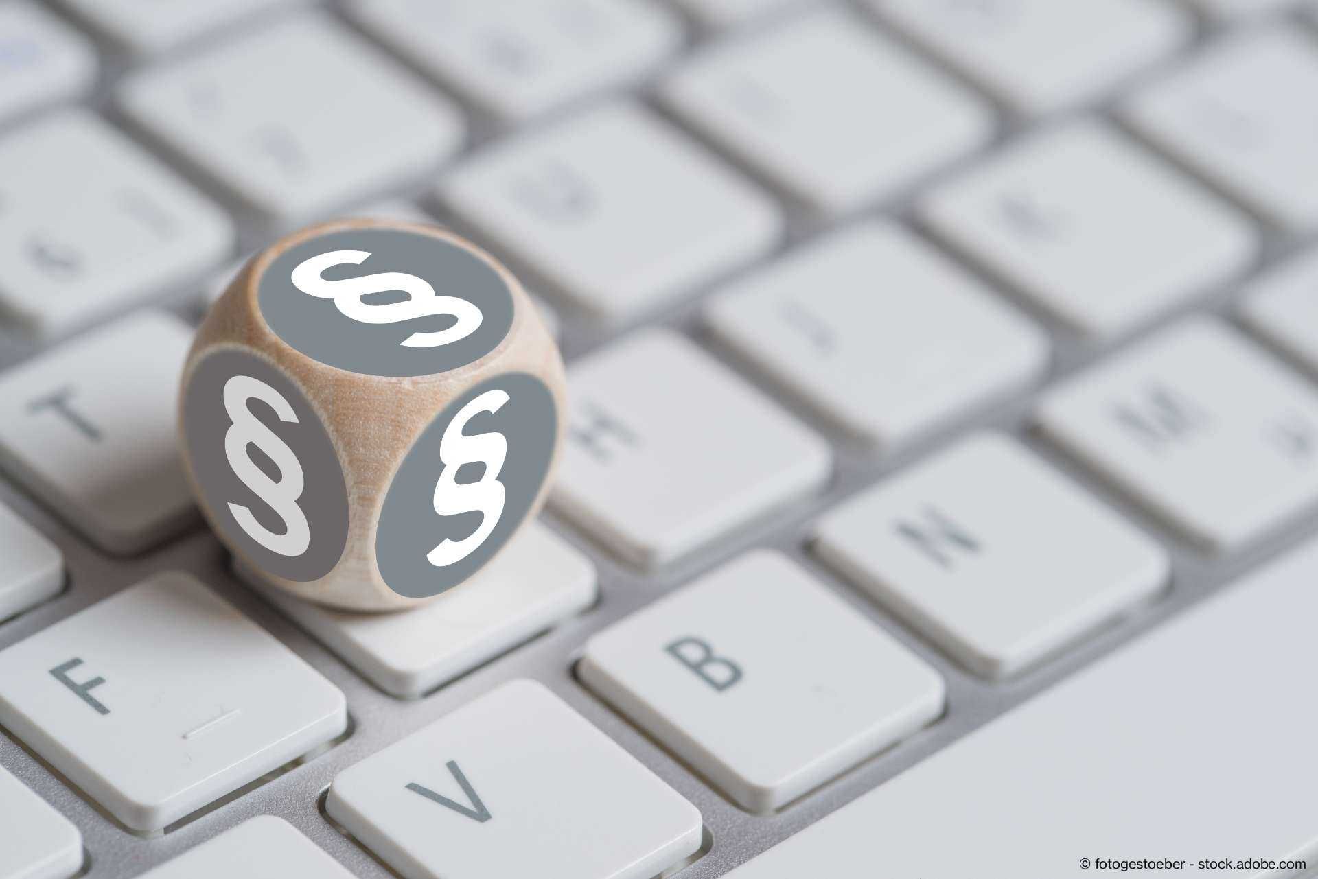 Würfel mit Paragraph Symbolen auf einer Tastatur 
