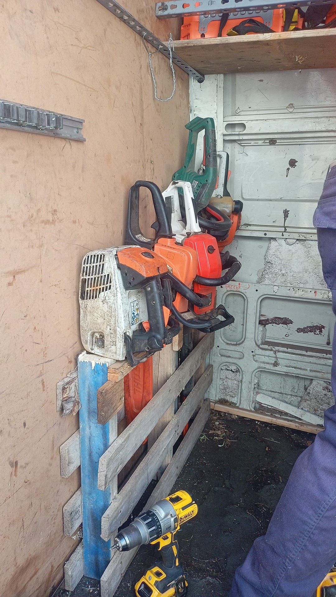 Motosierras y herramientas almacenadas dentro de un vehículo utilitario.