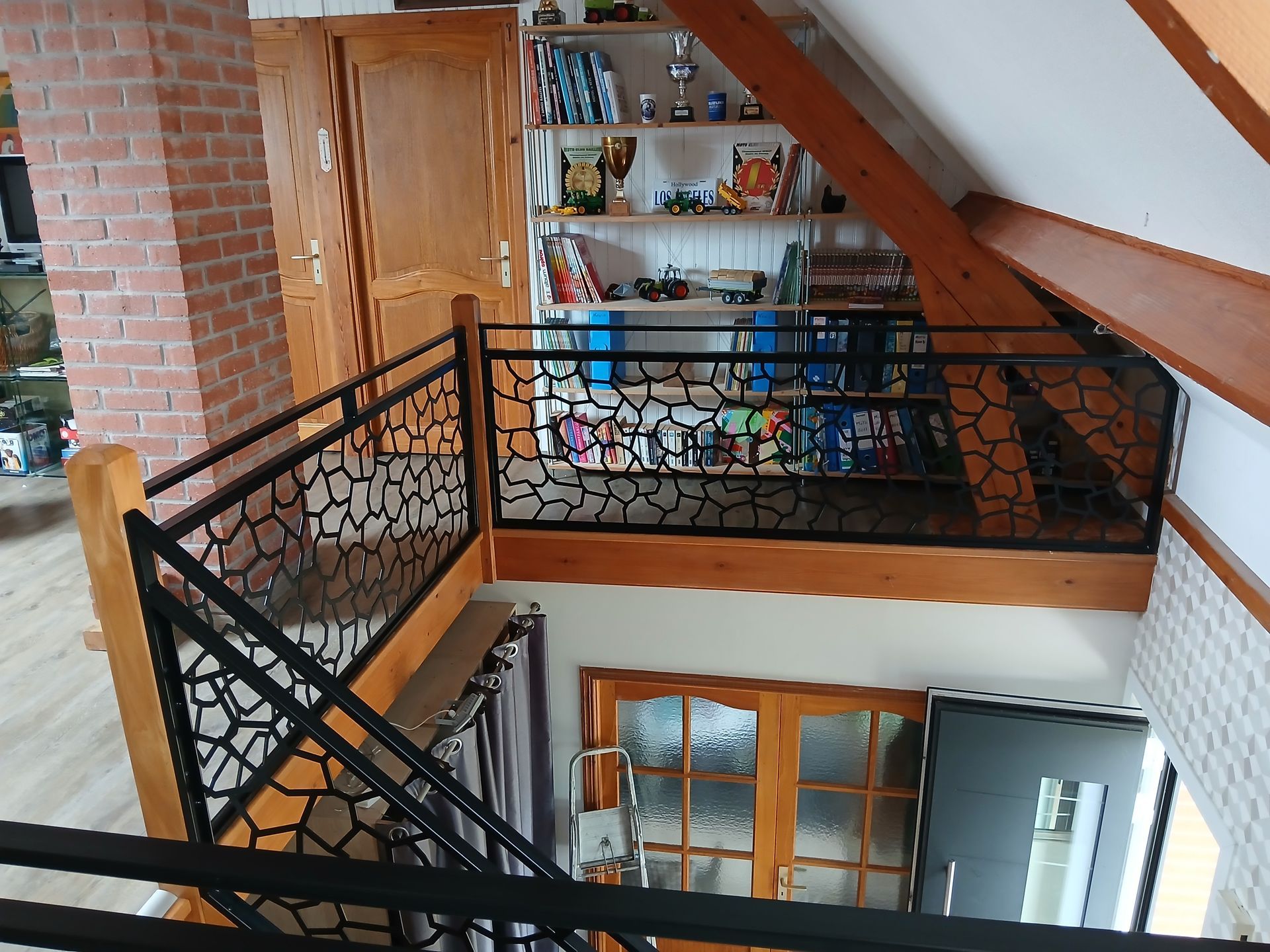 Rampe en métal noir et poutres en bois.