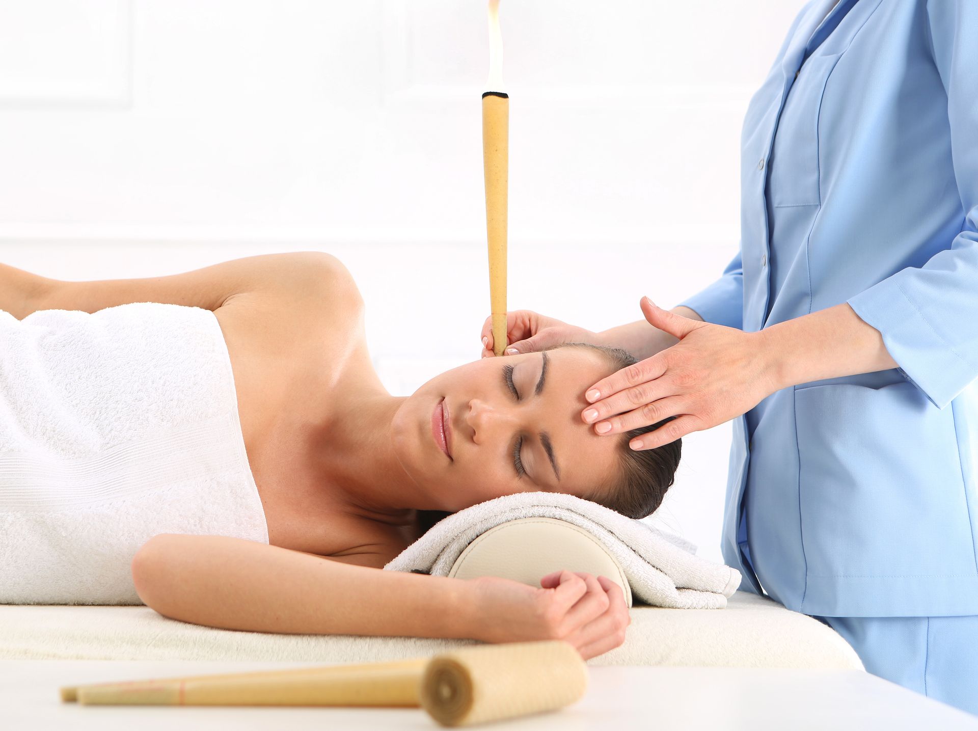 Femme recevant un massage de la tête aux pierres chaudes dans une salle de soins de spa.