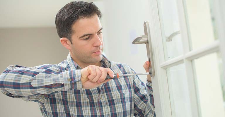 Homme qui change une poignet de prote avec un tournevisse