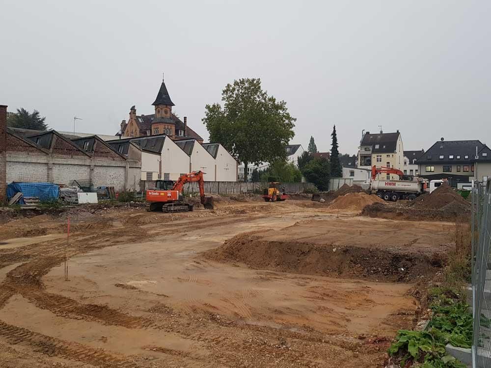 Eine Baustelle mit viel Schmutz und Gebäuden im Hintergrund