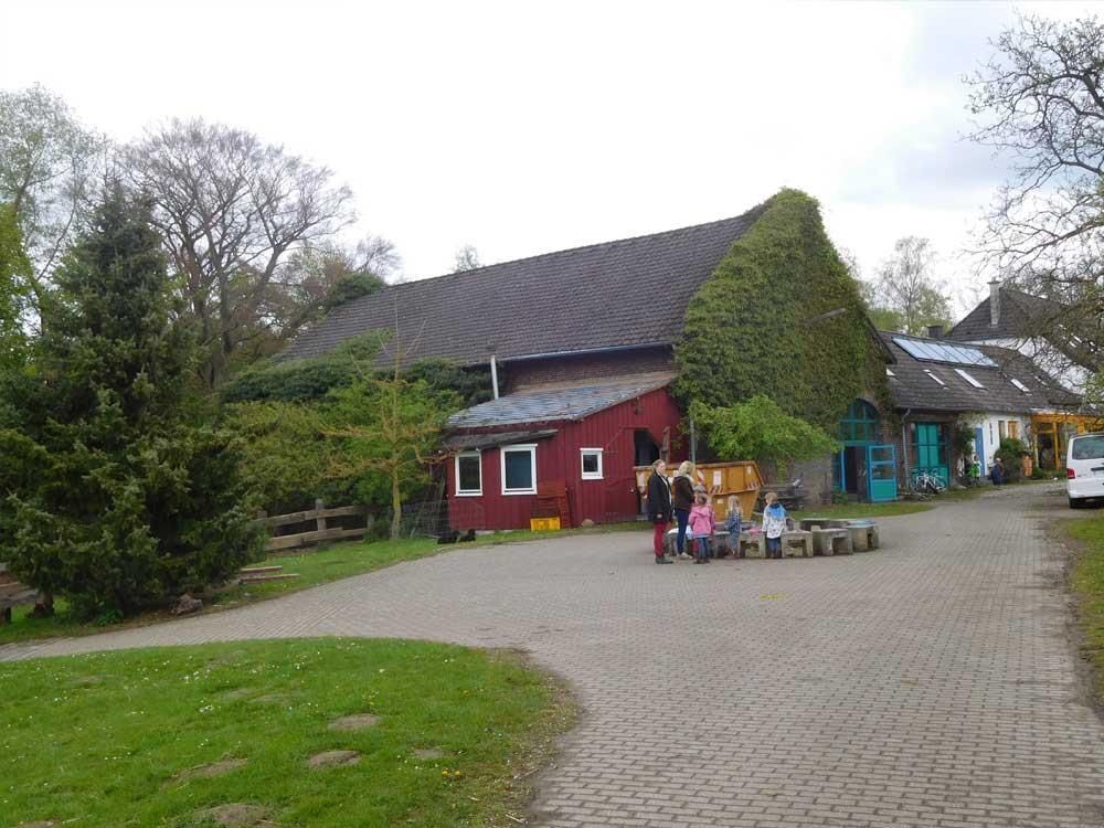 Eine Gruppe von Menschen steht vor einer roten Scheune