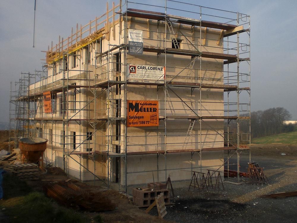 Ein im Bau befindliches Gebäude mit Gerüsten und einem Schild mit der Aufschrift Miru