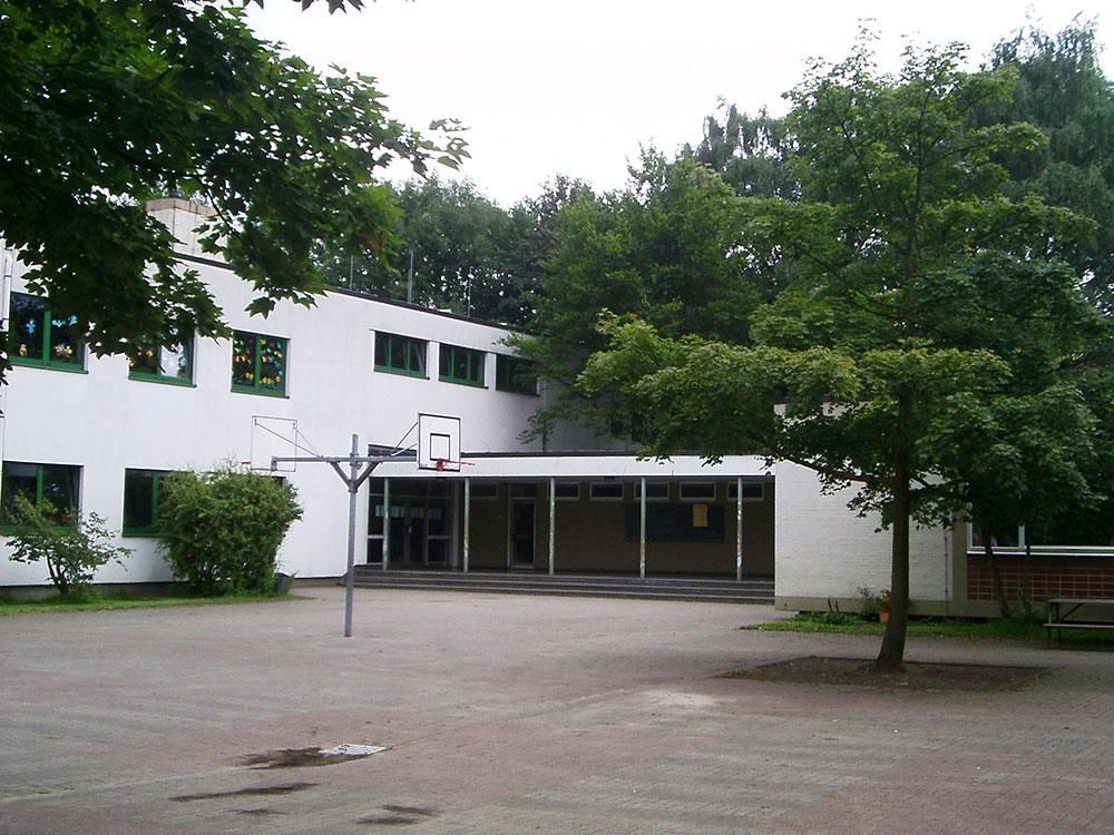 Ein weißes Gebäude mit einem Basketballkorb davor