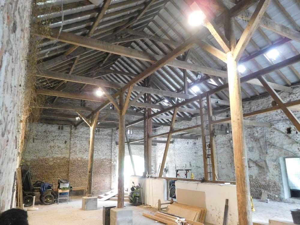 Ein großer Raum mit Holzbalken und einer Ziegelwand
