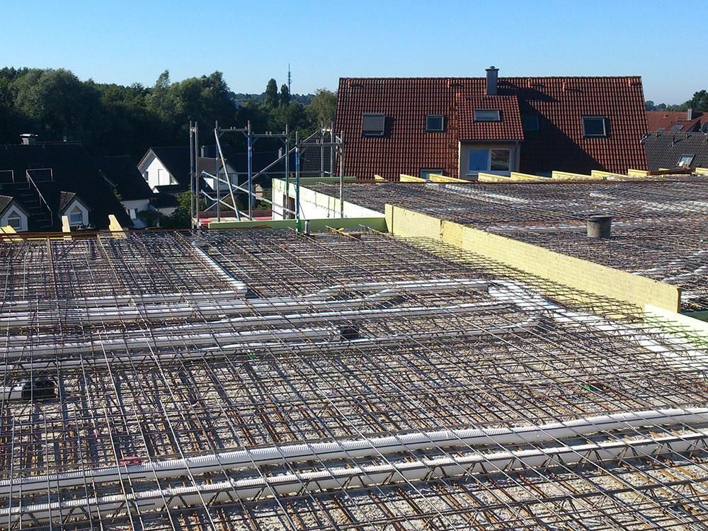 Das Dach eines im Bau befindlichen Gebäudes mit ein paar Häusern im Hintergrund