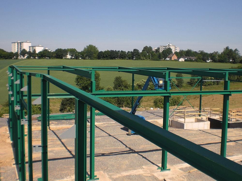 Auf einem Feld wird eine grüne Metallstruktur errichtet