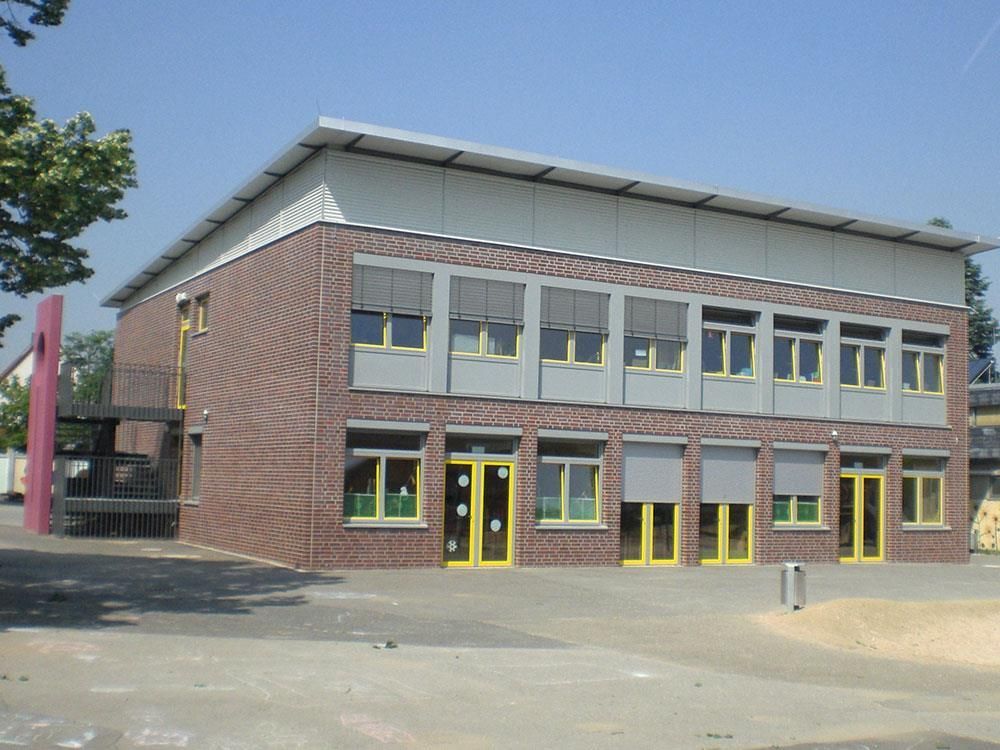 Ein großes Backsteingebäude mit vielen Fenstern und gelben Türen