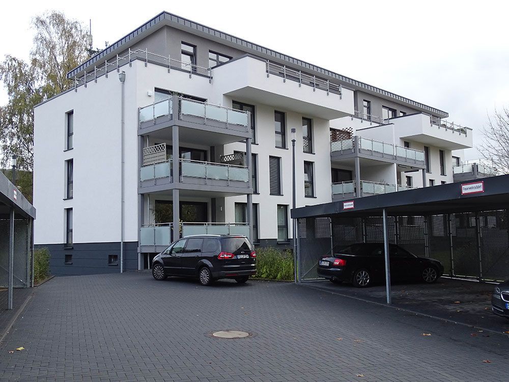 Ein schwarzes Auto steht vor einem weißen Gebäude