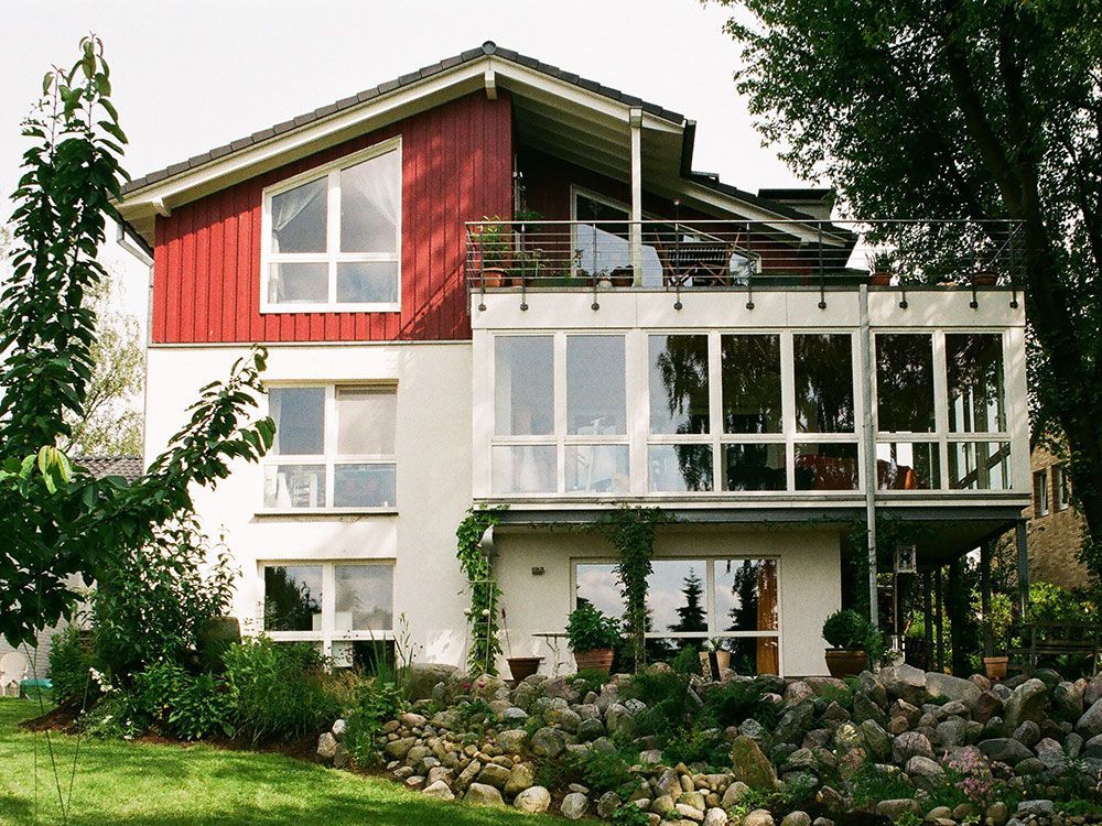 Ein rot-weißes Haus mit einem Balkon im zweiten Stock