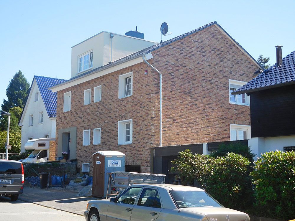 Ein Auto ist vor einem Backsteingebäude geparkt