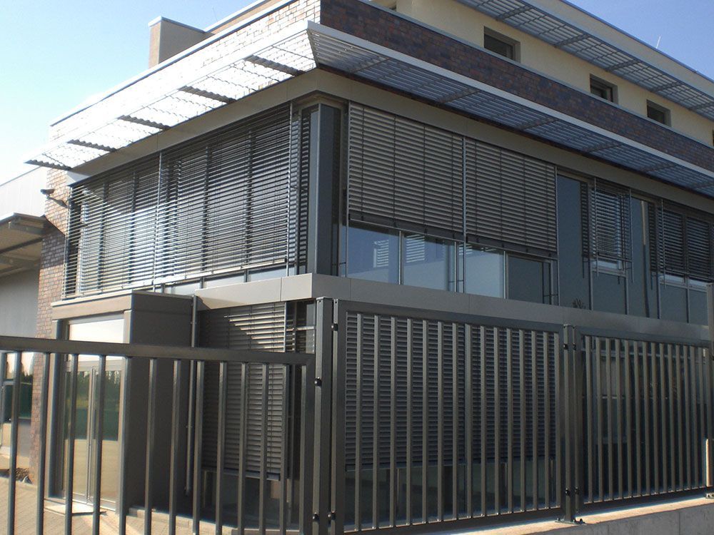 Ein Gebäude mit einem Zaun und vielen Fenstern