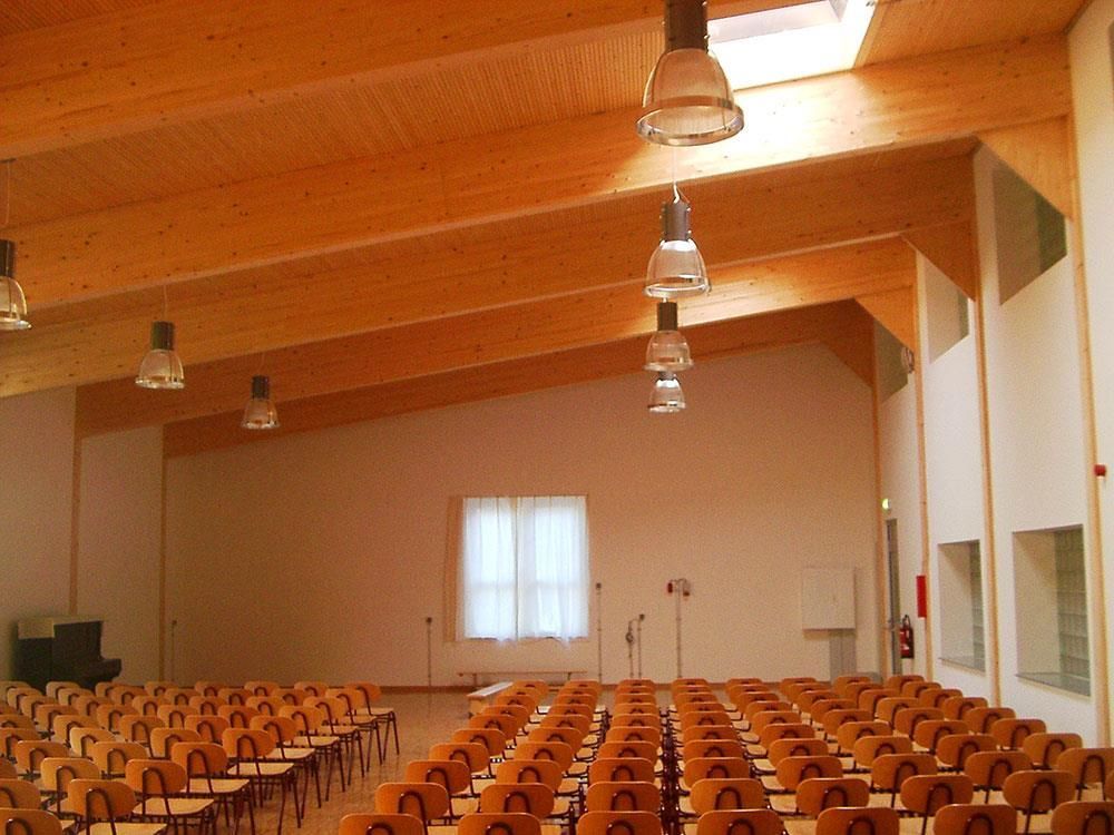 Stuhlreihen in einem großen Raum mit Holzdecke