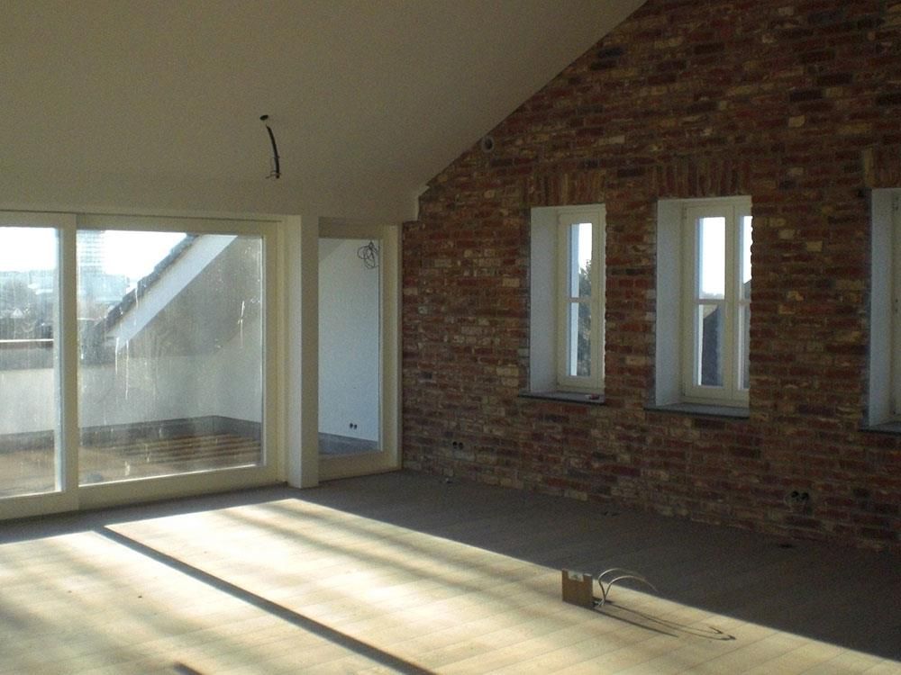Ein leerer Raum mit einer Ziegelwand und weißen Fenstern