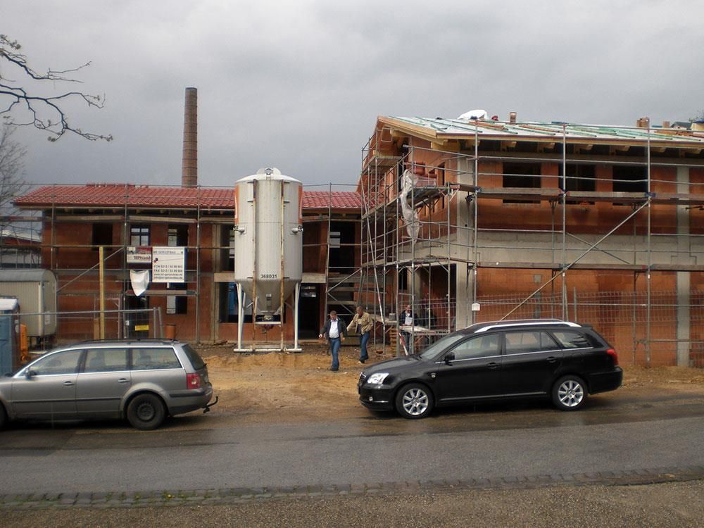 Ein Auto steht vor einem im Bau befindlichen Gebäude