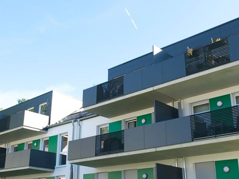 Ein Gebäude mit Balkonen und einem blauen Himmel im Hintergrund