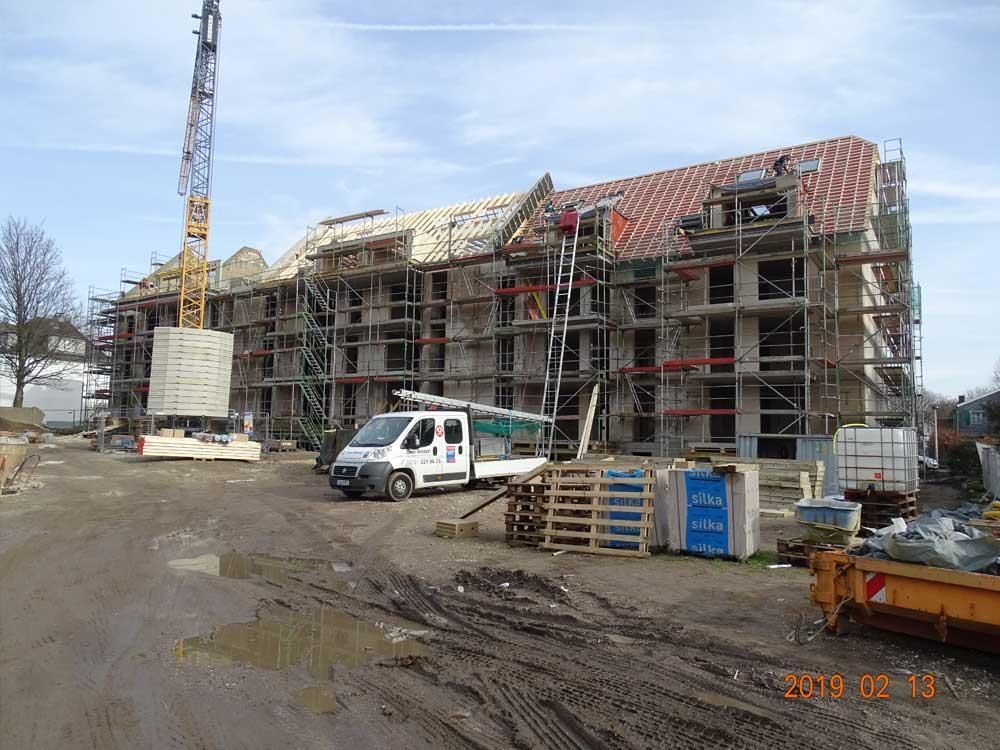 Ein weißer Lieferwagen steht vor einem im Bau befindlichen Gebäude