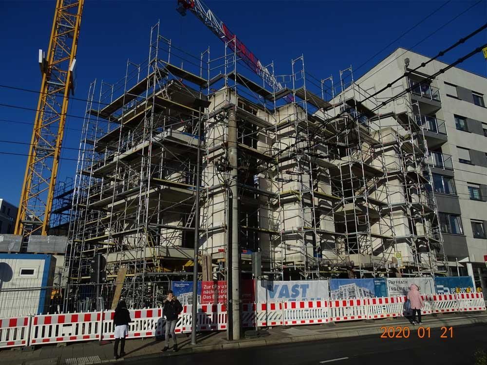 Ein großes Gebäude im Bau mit Gerüsten und einem Kran im Hintergrund