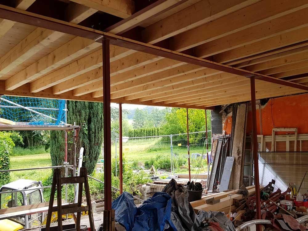 Ein im Bau befindliches Gebäude mit Holzbalken und einer Leiter