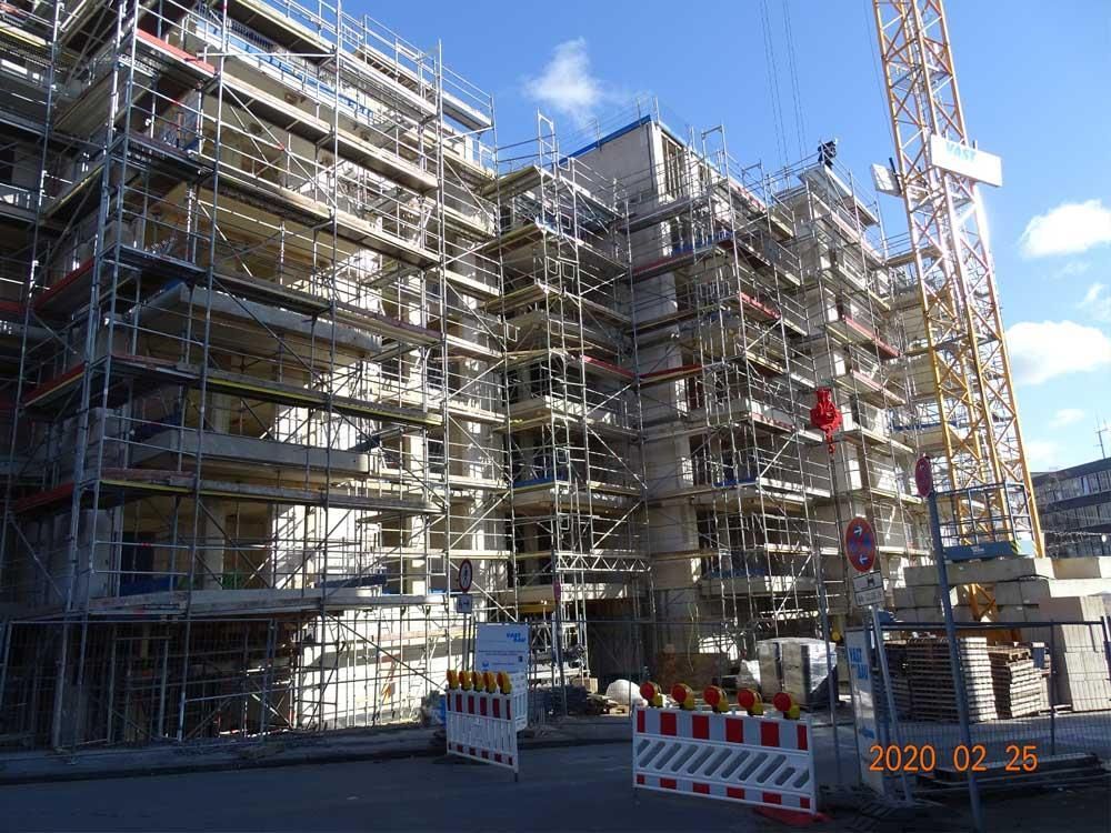 Ein im Bau befindliches Gebäude mit Gerüsten und einem Kran im Hintergrund