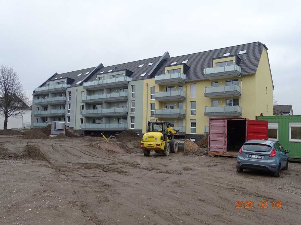 Ein gelber Bulldozer steht vor einem Gebäude